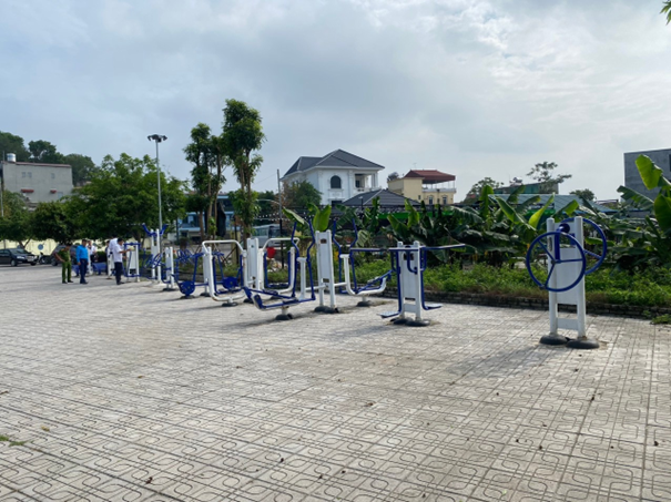 A group of people standing next to a row of exercise equipmentDescription automatically generated